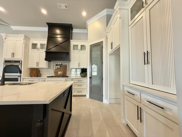 5516 E County Rd 93, Midland, TX 79706 - kitchen featuring stainless steel double oven, tasteful backsplash, crown molding, recessed lighting, and white cabinets