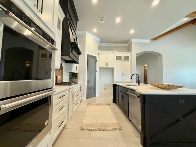 5516 E County Rd 93, Midland, TX 79706 - kitchen featuring stainless steel appliances, crown molding, light countertops, arched walkways, and an island with sink