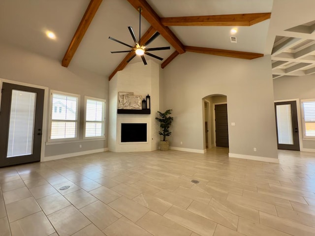 5516 E County Rd 93, Midland, TX 79706 - unfurnished living room with arched walkways, ceiling fan, healthy amount of natural light, beamed ceiling, and high vaulted ceiling