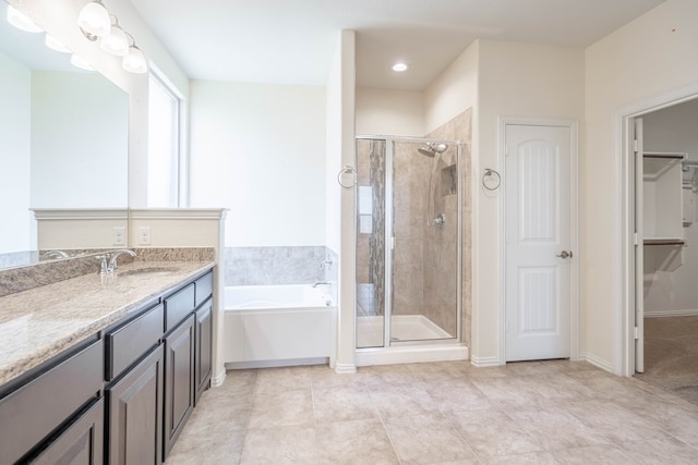 4906 Meadowside St, Midland, TX 79705 - full bathroom featuring a garden tub, a stall shower, vanity, a walk in closet, and tile patterned floors