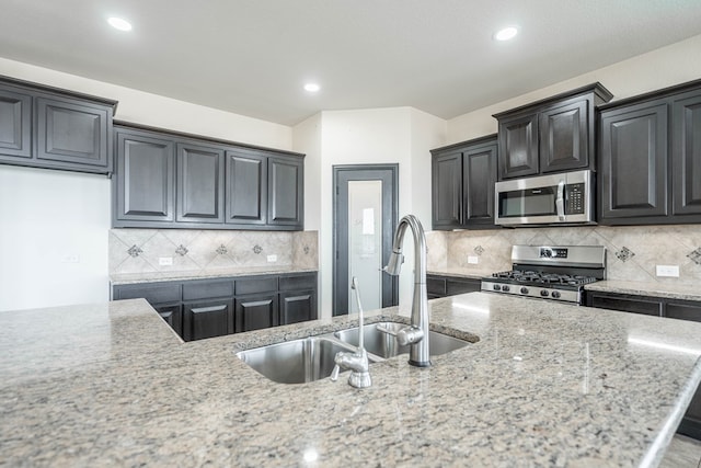 4906 Meadowside St, Midland, TX 79705 - kitchen featuring stainless steel appliances, light stone countertops, decorative backsplash, and recessed lighting