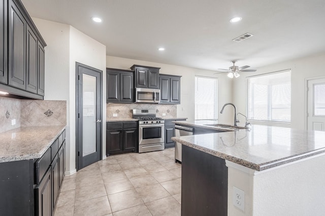 4906 Meadowside St, Midland, TX 79705 - kitchen featuring stainless steel appliances, backsplash, a ceiling fan, a spacious island, and recessed lighting