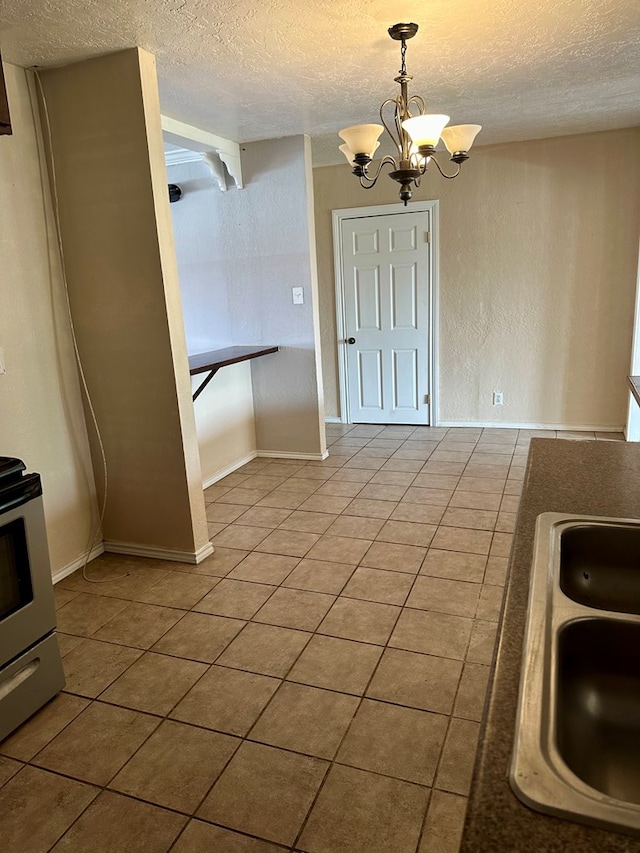 kitchen with a textured ceiling, tile patterned flooring, hanging light fixtures, and a notable chandelier