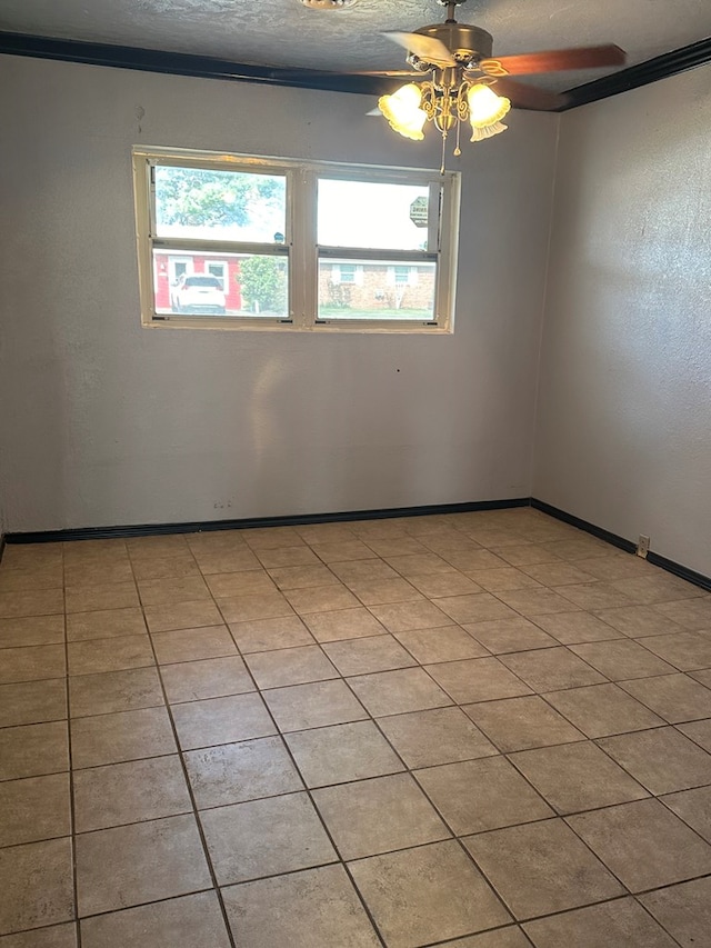 unfurnished room featuring light tile patterned floors, a textured ceiling, a wealth of natural light, and ornamental molding