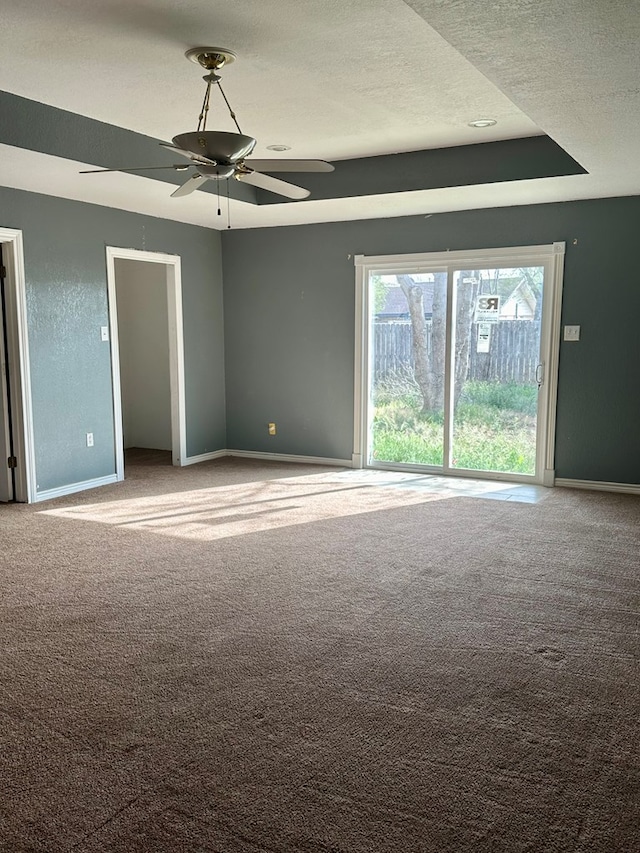 carpeted empty room with ceiling fan and a textured ceiling