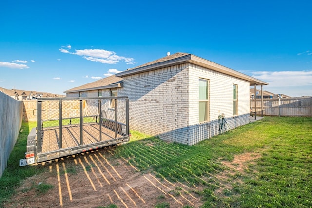 6909 Moonlight, Midland, TX 79705 - view of home's exterior featuring a fenced backyard, brick siding, and a lawn