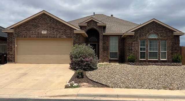 1419 San Miguel Ct, Midland, TX 79705 - view of front of home with brick siding, a shingled roof, concrete driveway, and a garage