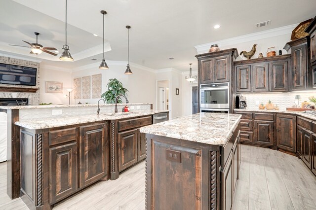 4506 San Pedro Ct, Midland, TX 79707 - kitchen with visible vents, a sink, light wood-style flooring, and a center island with sink