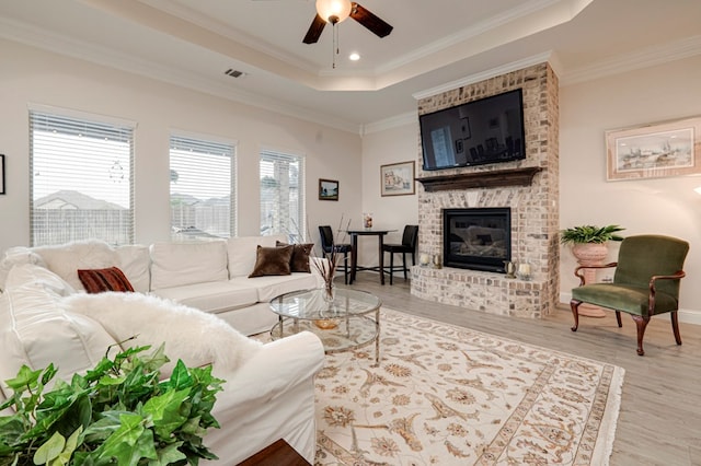 4506 San Pedro Ct, Midland, TX 79707 - living room with a brick fireplace, ceiling fan, wood finished floors, and a tray ceiling