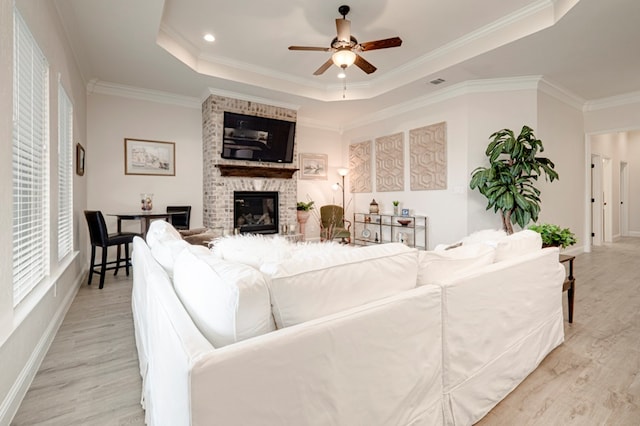 4506 San Pedro Ct, Midland, TX 79707 - living room featuring light wood-style floors, ornamental molding, ceiling fan, and a tray ceiling
