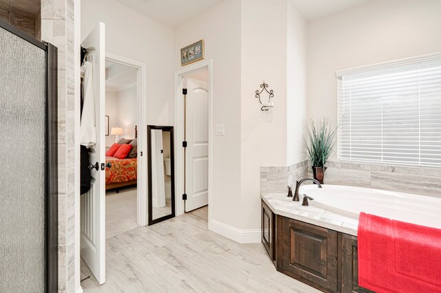 4506 San Pedro Ct, Midland, TX 79707 - bathroom with a garden tub, a shower stall, wood finished floors, baseboards, and connected bathroom