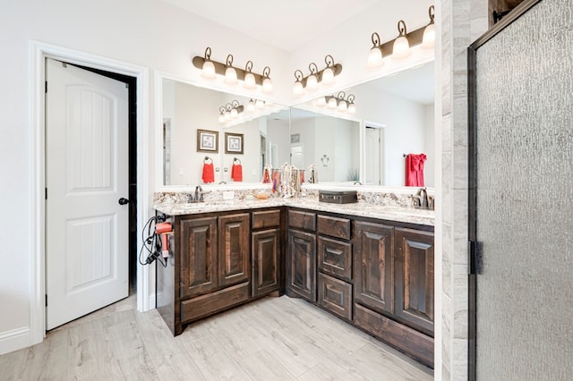 4506 San Pedro Ct, Midland, TX 79707 - bathroom with an enclosed shower, double vanity, a sink, and wood finished floors