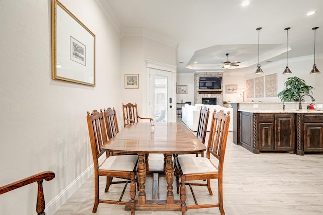4506 San Pedro Ct, Midland, TX 79707 - dining area with a ceiling fan, crown molding, a fireplace, a raised ceiling, and recessed lighting