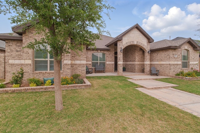 4506 San Pedro Ct, Midland, TX 79707 - french country style house with brick siding, a patio, and a front lawn