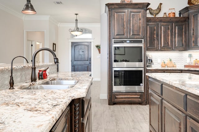 4506 San Pedro Ct, Midland, TX 79707 - kitchen with crown molding, dark brown cabinets, double oven, tasteful backsplash, and a sink