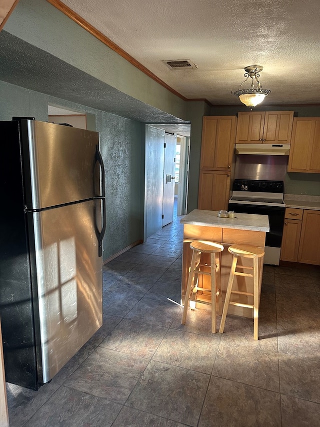 kitchen with a textured ceiling, white range, crown molding, fridge, and a breakfast bar area