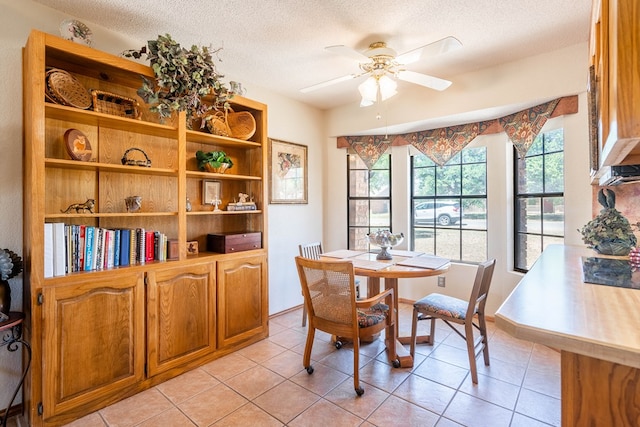 dining room featuring light tile patterned floors, a ceiling fan, and a textured ceiling