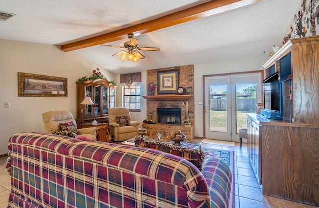 living area featuring a fireplace, a ceiling fan, plenty of natural light, and vaulted ceiling with beams