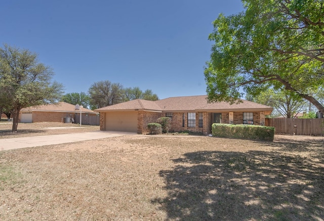 single story home with a garage, brick siding, fence, and driveway