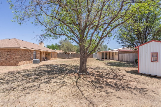 view of yard with a storage unit, fence, and an outdoor structure