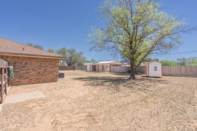 view of yard featuring an outbuilding, a shed, and a fenced backyard