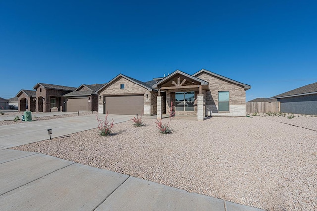 6803 Leather Ln, Midland, TX 79705 - view of front of house with driveway, fence, a garage, and stone siding