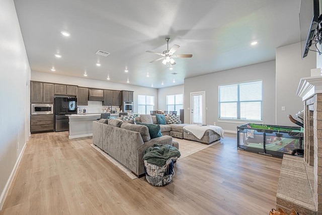 6803 Leather Ln, Midland, TX 79705 - living room featuring a fireplace, a ceiling fan, light wood finished floors, baseboards, and recessed lighting
