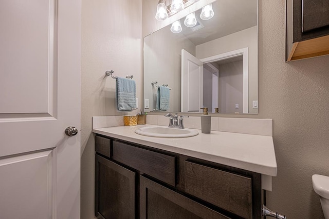 6803 Leather Ln, Midland, TX 79705 - bathroom with toilet, vanity, and a textured wall