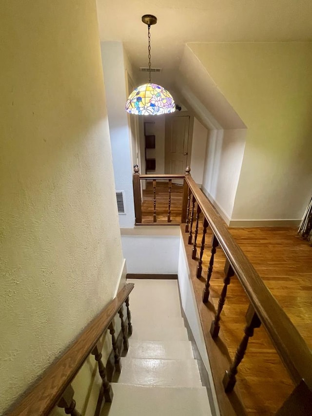 staircase with hardwood / wood-style flooring and lofted ceiling