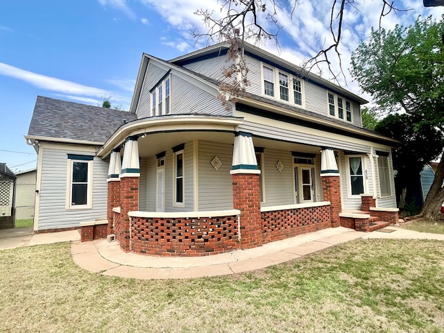 view of front of house with covered porch and a front lawn