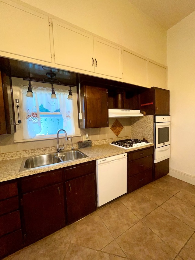 kitchen featuring white appliances, sink, and light tile patterned floors