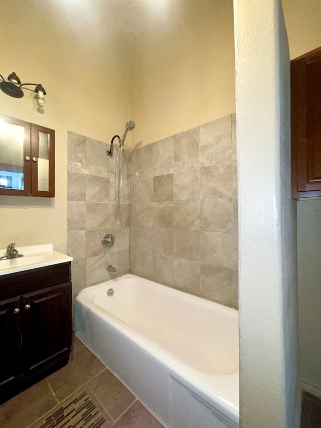 bathroom with tile patterned flooring, vanity, and tiled shower / bath