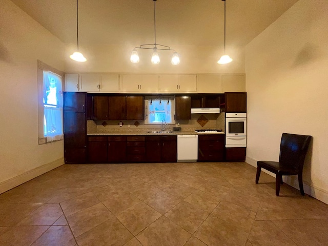 kitchen featuring dark brown cabinets, white appliances, vaulted ceiling, sink, and decorative light fixtures