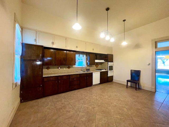 kitchen with white appliances, sink, light tile patterned floors, decorative light fixtures, and dark brown cabinetry