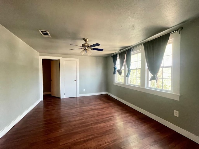 spare room with ceiling fan, dark hardwood / wood-style flooring, and a textured ceiling