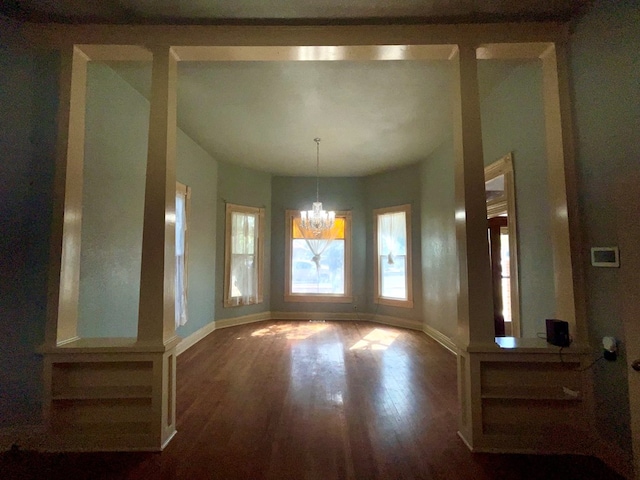 unfurnished dining area with a chandelier and hardwood / wood-style floors