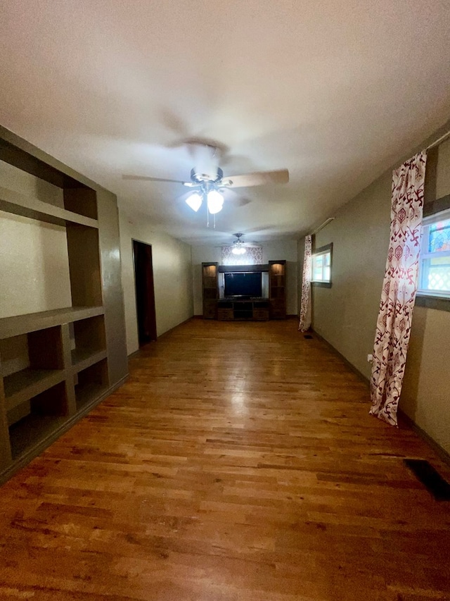 unfurnished living room with hardwood / wood-style floors and ceiling fan