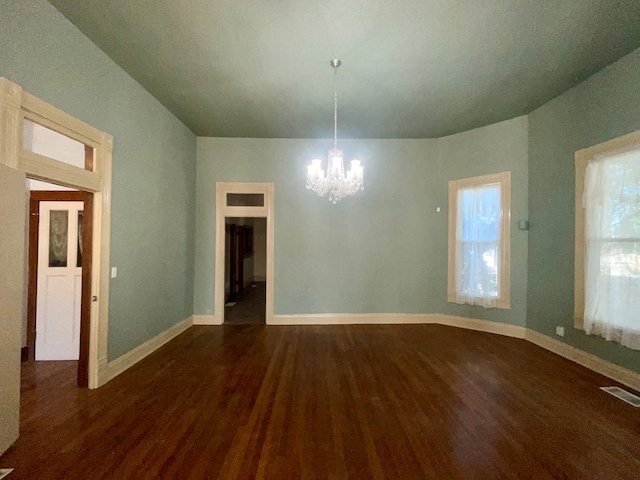 unfurnished dining area with dark hardwood / wood-style flooring and a notable chandelier