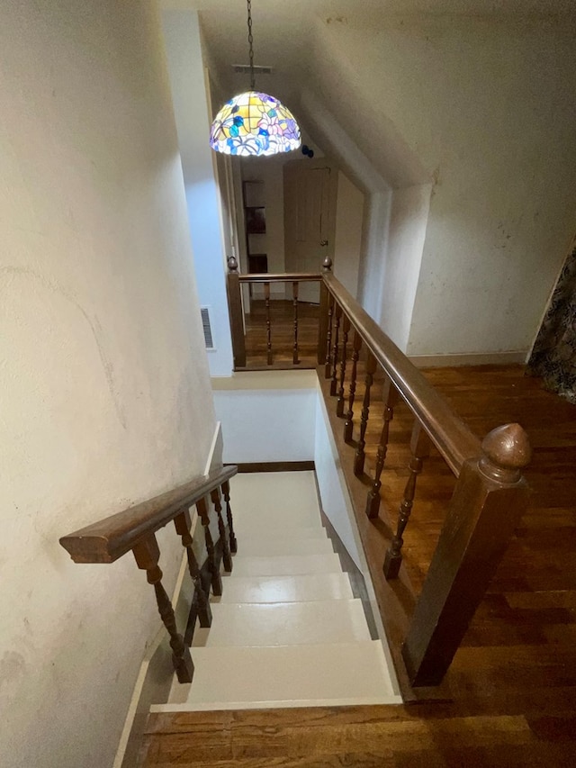 stairs with hardwood / wood-style flooring and lofted ceiling