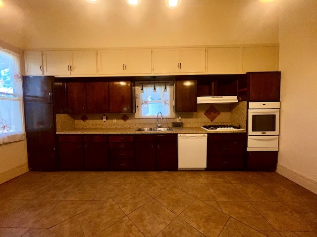 kitchen with light tile patterned flooring, white appliances, and sink