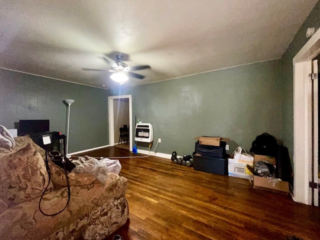 sitting room featuring hardwood / wood-style flooring, heating unit, and ceiling fan