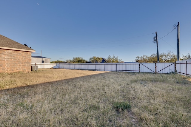 view of yard featuring fence and central AC unit