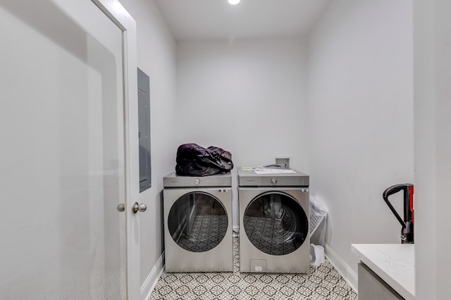 laundry room featuring laundry area, light tile patterned floors, baseboards, and separate washer and dryer