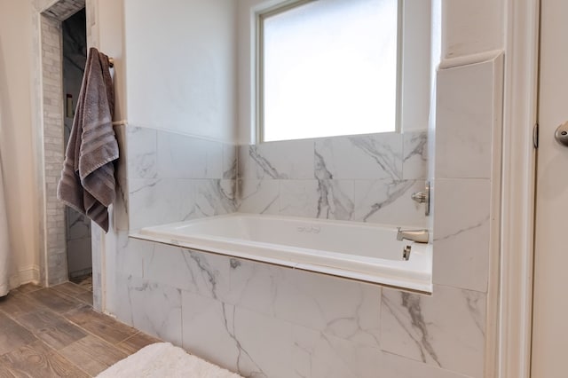 full bathroom featuring wood finished floors and a garden tub