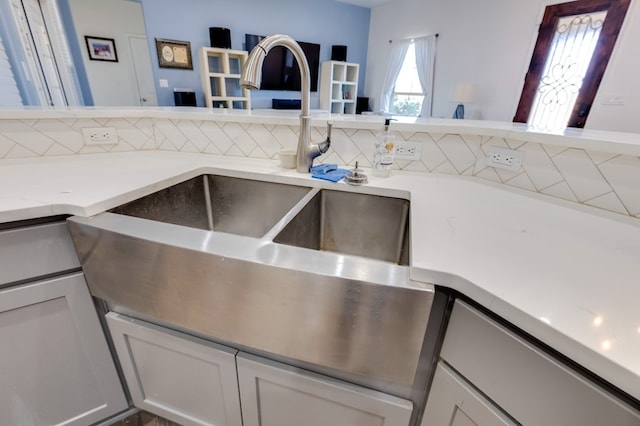 kitchen with white cabinetry, a sink, and backsplash