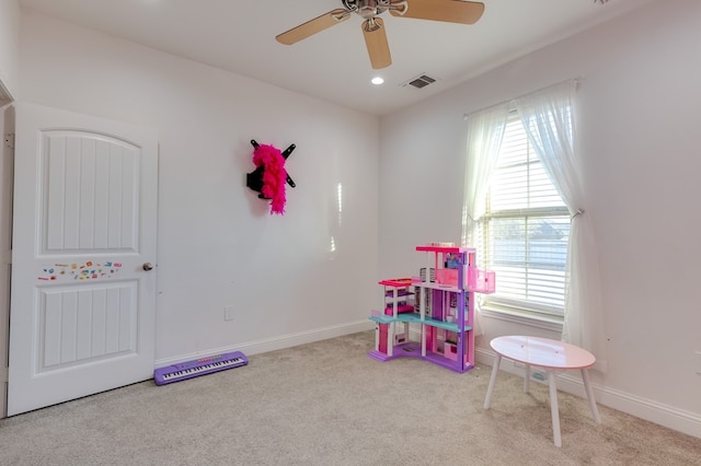 playroom with carpet floors, baseboards, visible vents, and ceiling fan