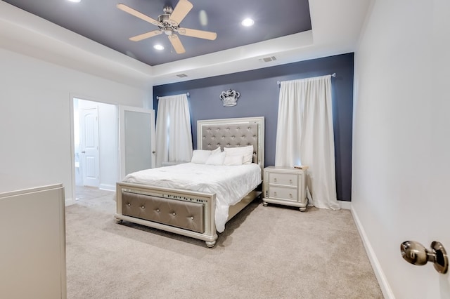 carpeted bedroom featuring baseboards, visible vents, a raised ceiling, and recessed lighting