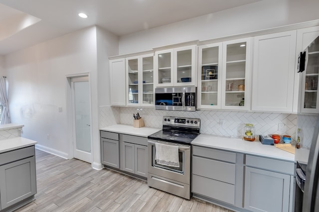 kitchen with stainless steel appliances, backsplash, and gray cabinetry