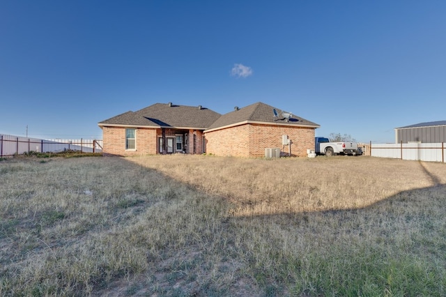 back of house with fence, central AC, and brick siding