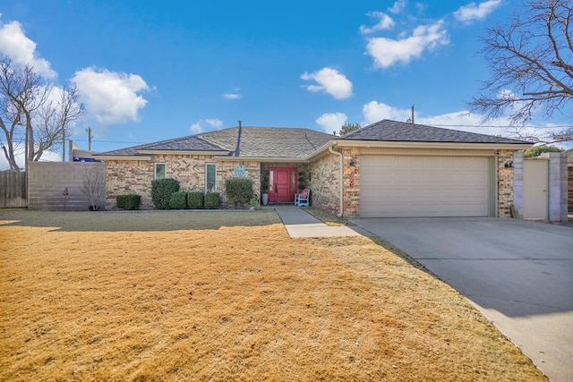 ranch-style home featuring an attached garage, brick siding, fence, concrete driveway, and a front yard